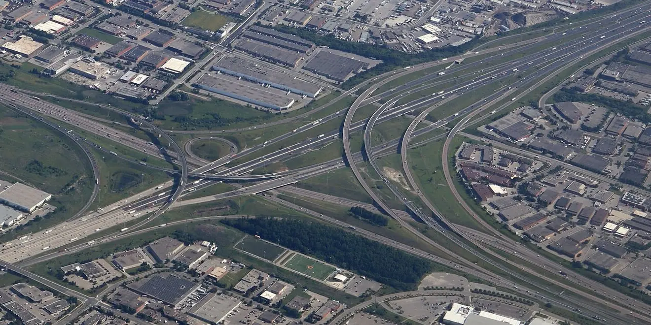 Aerial view of a motorway interchange, its ramps curving over the main carriageway